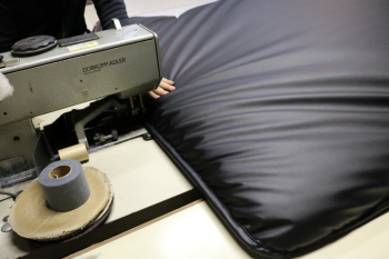 SHINKEフルフラットマットを専用ミシンで縫製する工程